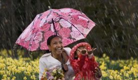 African mother and daughter playing in the rain