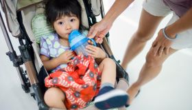 Toddler girl drinking water in stroller