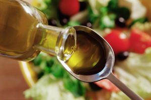 Olive oil pouring on to a spoon