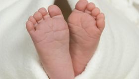 Pair of baby's feet poking out from blanket, close-up