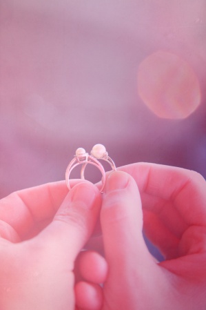 Women holding pearl engagement rings