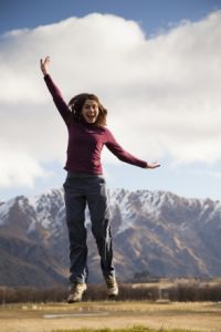 Young woman jumping on idyllic landscape