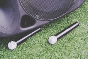 High Angle View Of Microphones And Speaker On Grassy Field