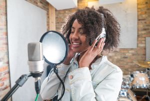 Woman singing at a recording studio