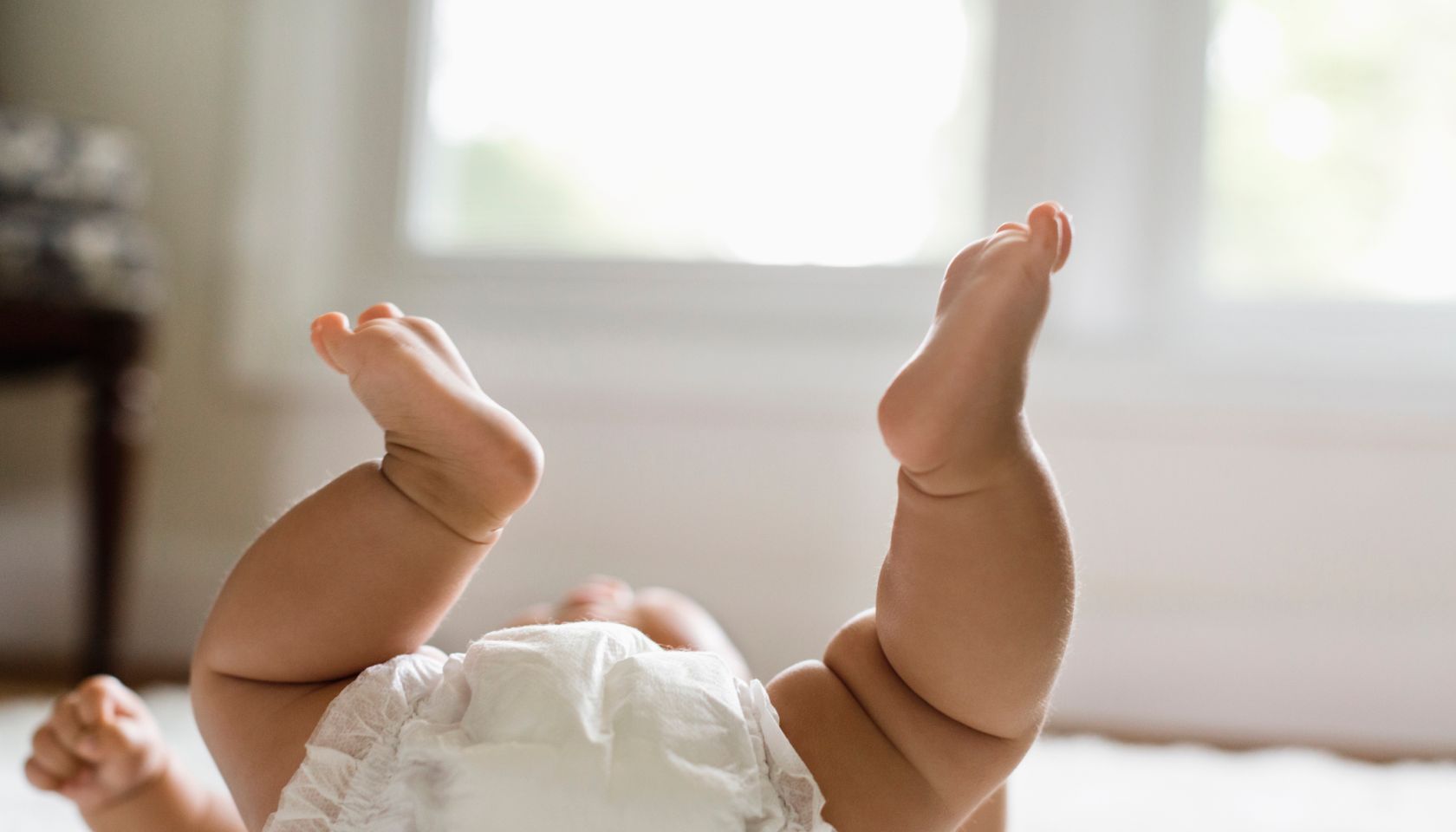 Mixed race baby girl laying on floor