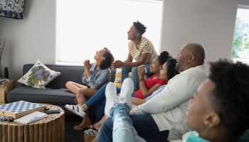 African American family watching TV in living room