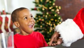 Surprised little boy sees Santa taking Christmas cookie