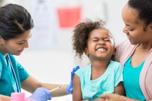 Young girl grimaces while getting a shot