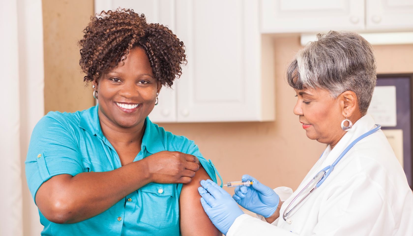 Doctor or nurse gives flu vaccine to patient at clinic.