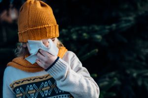 Little boy having a cold, blowing his nose