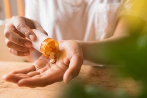 Hands of African American woman holding prescription medicine