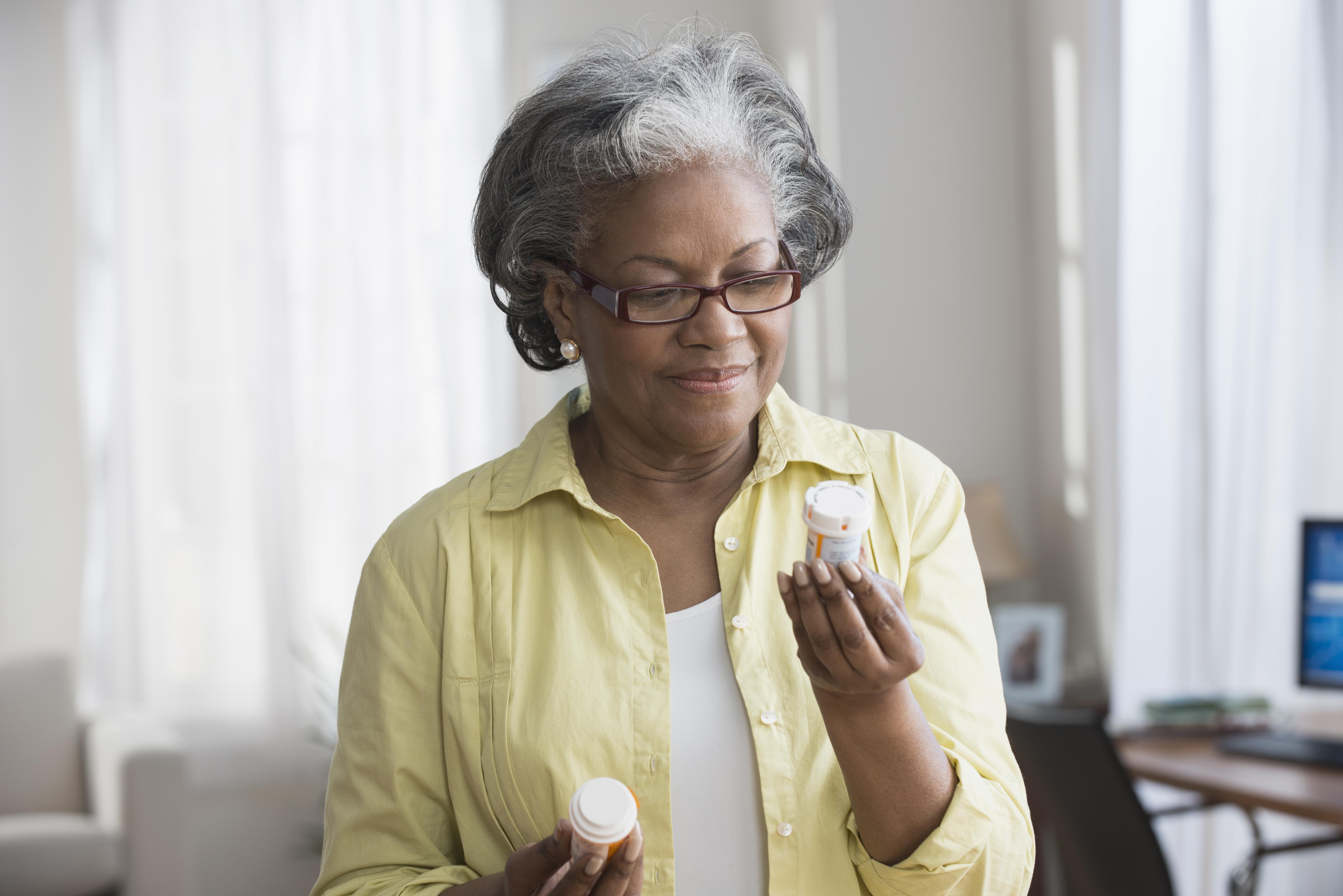 Black woman reading prescription bottles