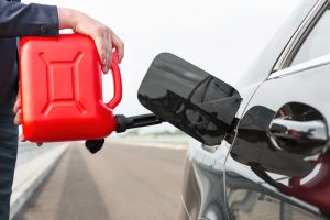 Businesswoman fueling car with petrol can
