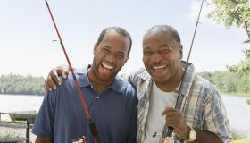 Portrait of father and son with fishing poles