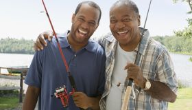Portrait of father and son with fishing poles