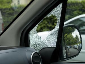 Broken side window of burglarized car, street view
