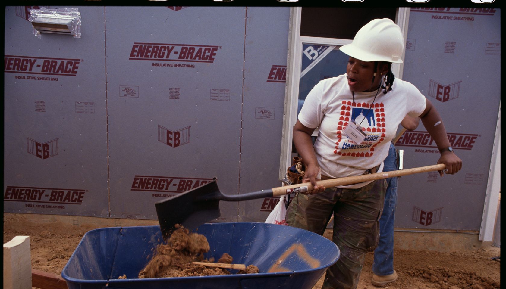 Habitat for Humanity Worker Shovels Dirt Into Wheelbarrow