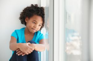 Black girl sitting in windowsill