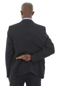 An African-American businessman with his fingers crossed behind his back