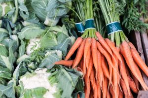 Carrots and cauliflower for sale on display on a counter.