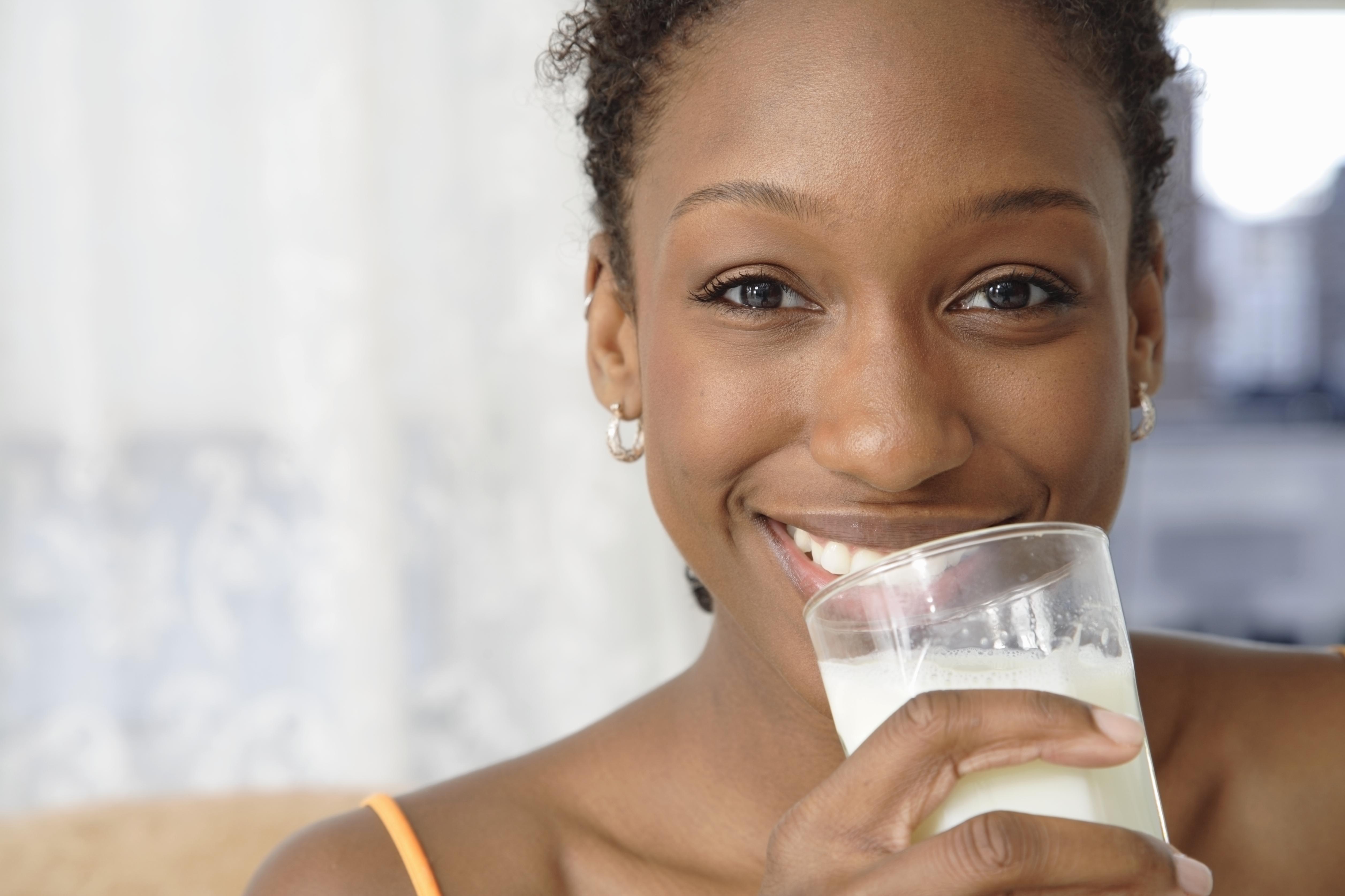 Portrait of woman holding glass of milk, close up