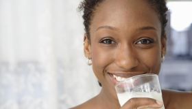 Portrait of woman holding glass of milk, close up