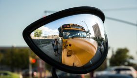 Photographer Taking Self Portrait In Side-View Mirror Of School Bus