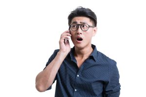 Shocked young man talking on cell phone