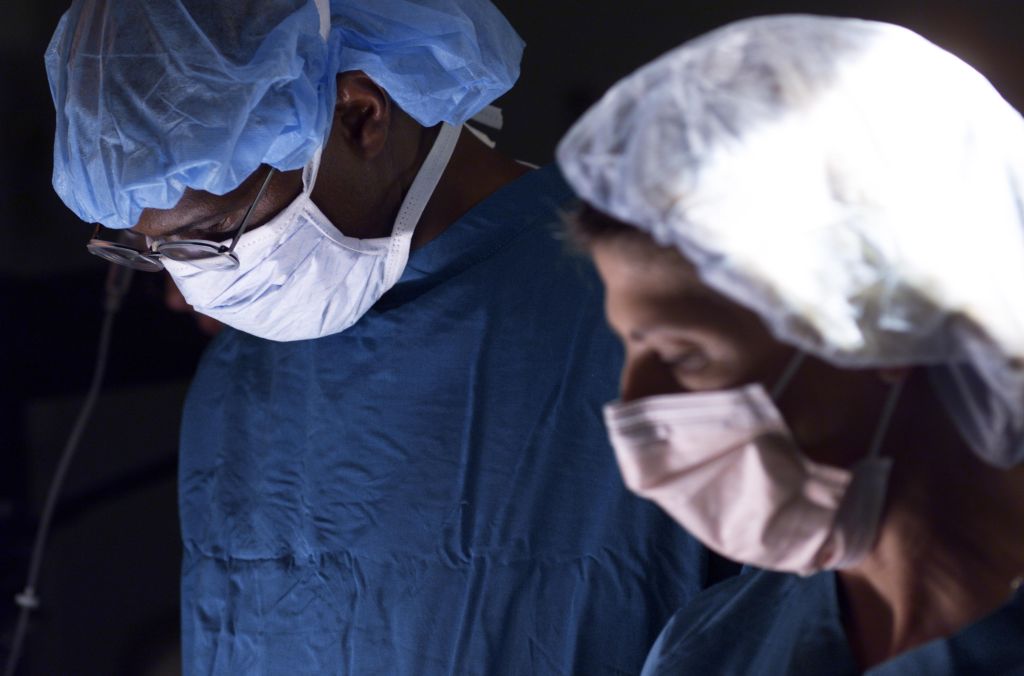 a male doctor and a female nurse work together in during an operation