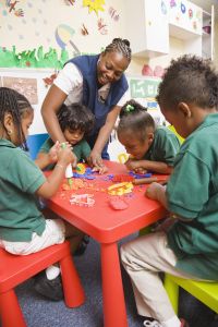Teacher with students playing with play dough