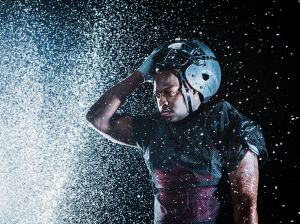 Water splashing on black football player