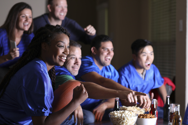 Football fans watching the game at home on television.