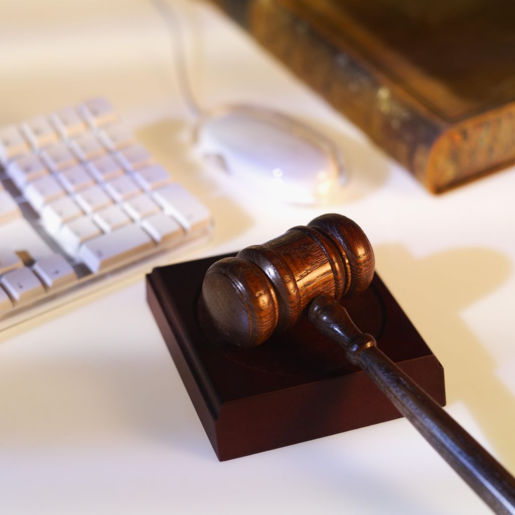 Close-up of computer keyboard and mouse with textbook and gavel beside it