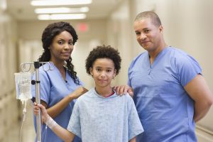 Doctors and patient with IV in hospital corridor