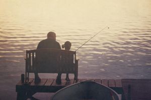 Father and daughter fishing off of pier