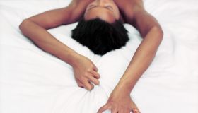 Woman Gripping Sheets During Lovemaking
