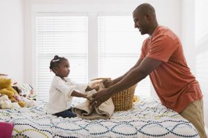 Father and daughter folding laundry