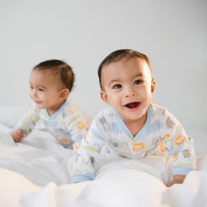 Mixed race twins crawling on bed