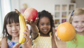 Children holding out fresh fruit