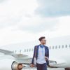 Young african businessman walking in front of airplane