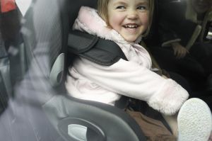 Laughing girl sitting in car seat