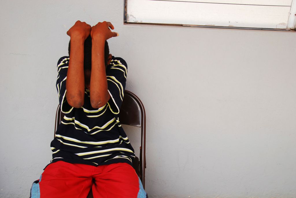 Dominica, Roseau, Juveniles Prison social center, teenager hiding his face