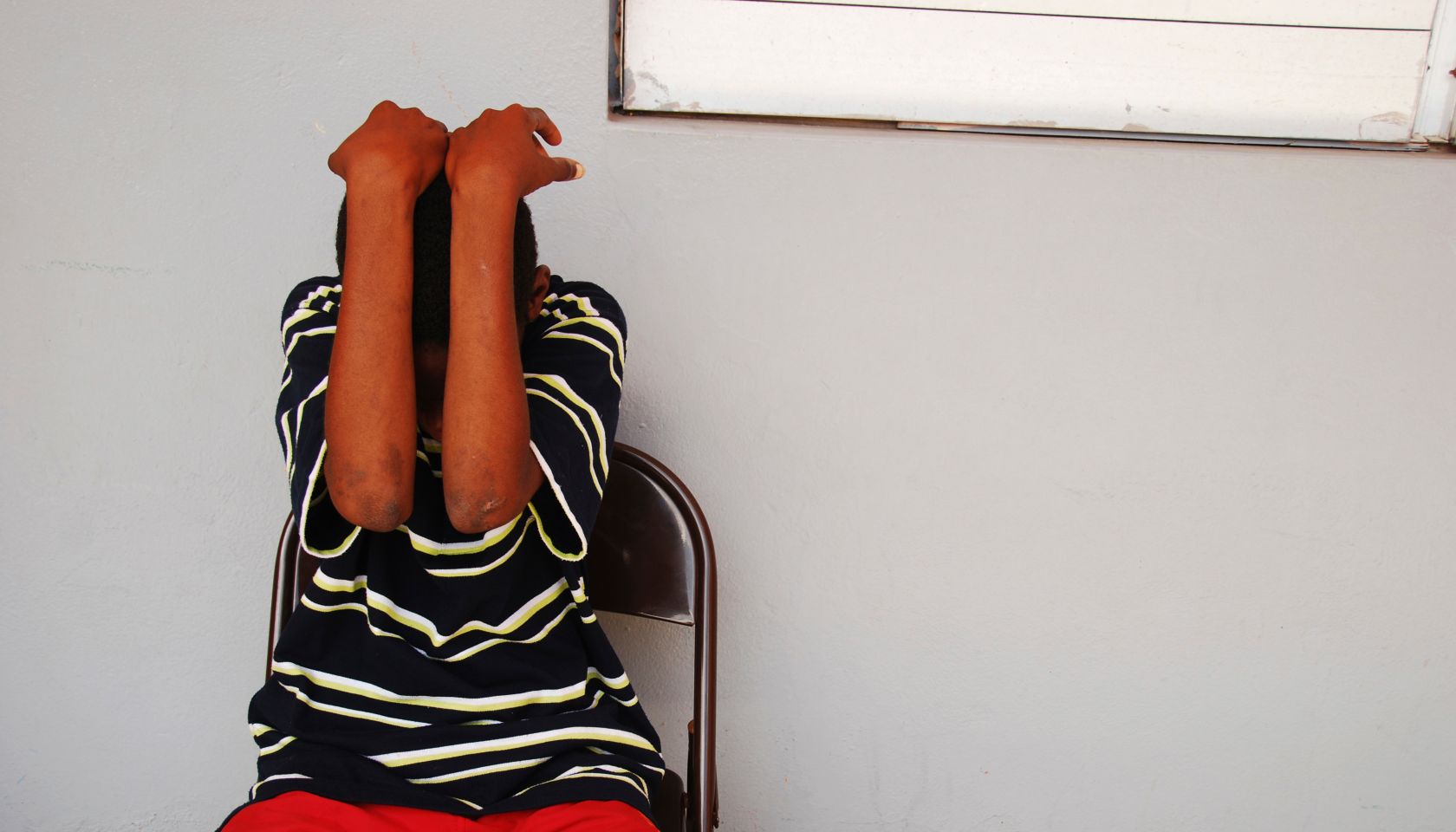 Dominica, Roseau, Juveniles Prison social center, teenager hiding his face