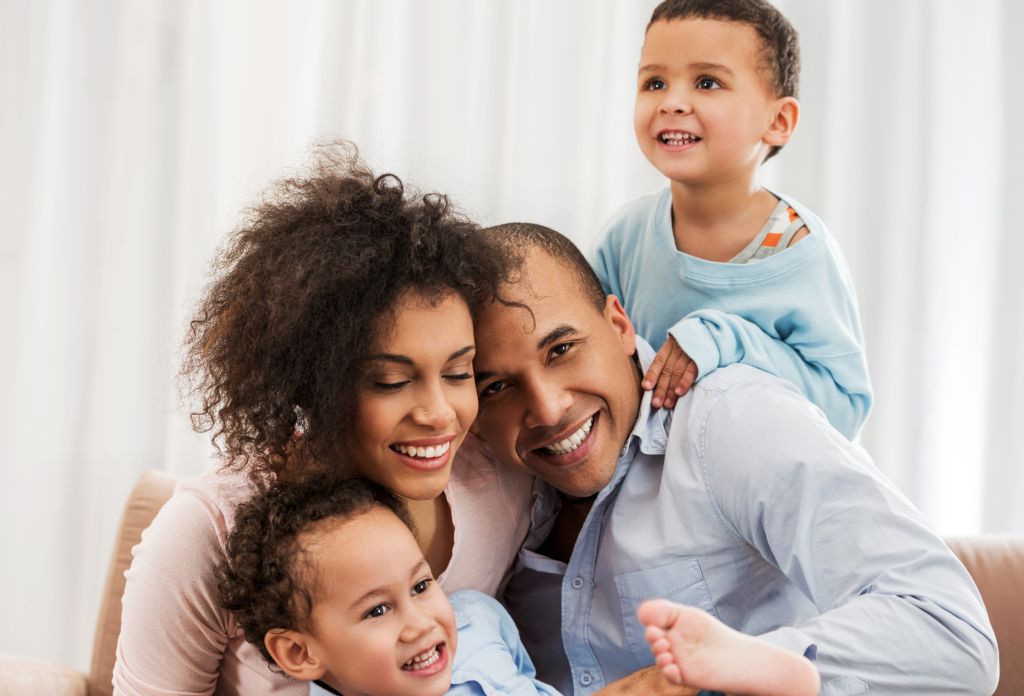 Portrait of cheerful African American family at home.