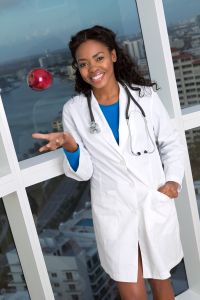 African American female doctor tossing apple