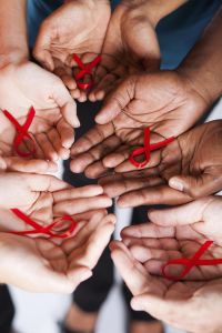 group of multiracial people holding red ribbon with both hands