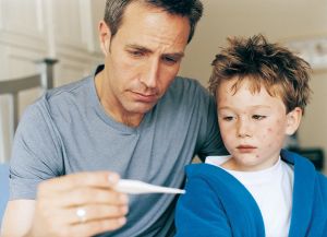 Father Checking Temperature of Son Sick With Chickenpox