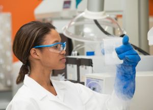 Black scientist examining liquid in laboratory