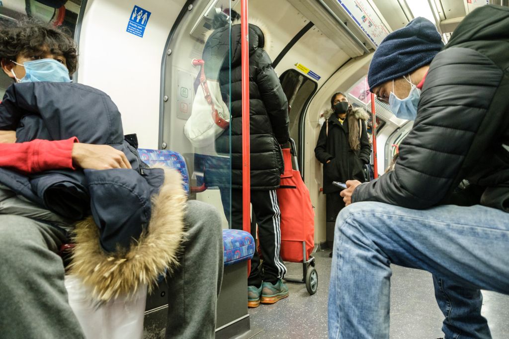 People wearing masks travel on the Victoria Line of the London Underground, London on Friday, Mar. 20, 2020 .