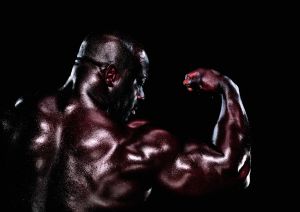 Male body builder flexing bicep, rear view, close-up